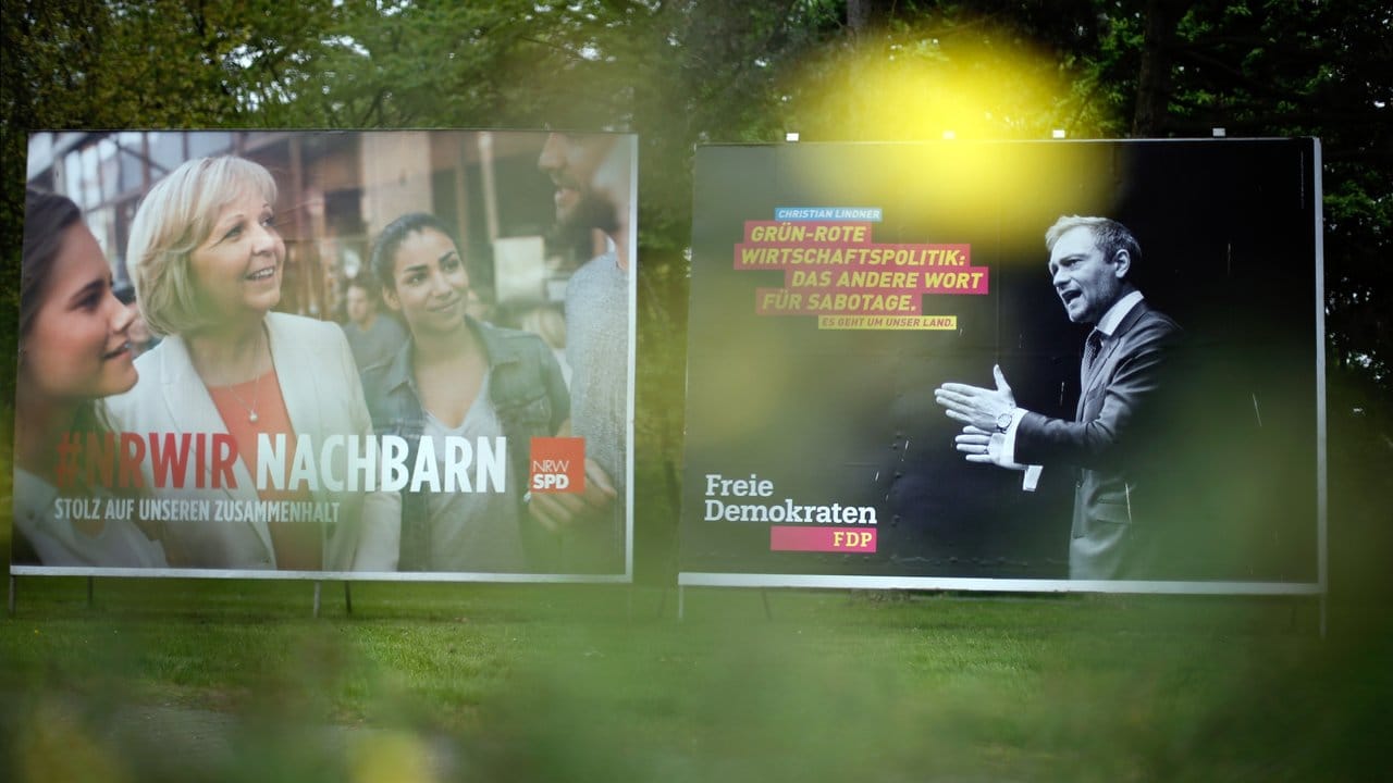 Wahlplakate der NRW-Ministerpräsidentin Hannelore Kraft (l, SPD) und des Vorsitzenden der FDP, Christian Lindner, stehen in Duisburg.