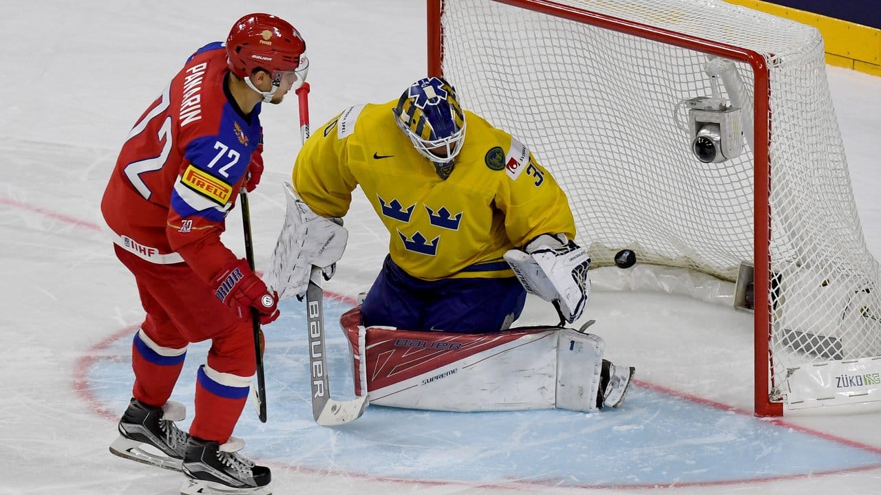 Russlands Artemi Panarin (l) erzielt beim Penalty-Schießen an Schwedens Torwart Viktor Fasth vorbei den entscheidenden Treffer.