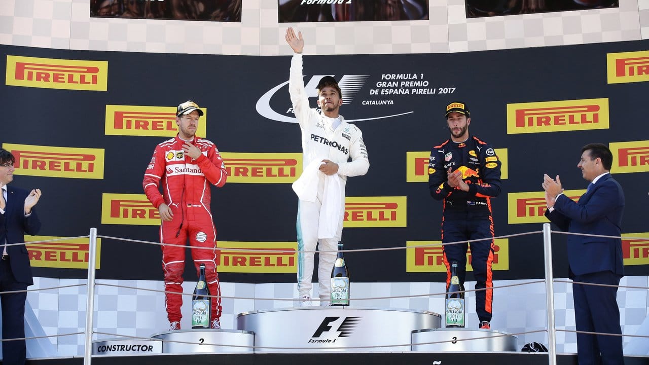 Sieger Lewis Hamilton (M) winkt vom Podium.