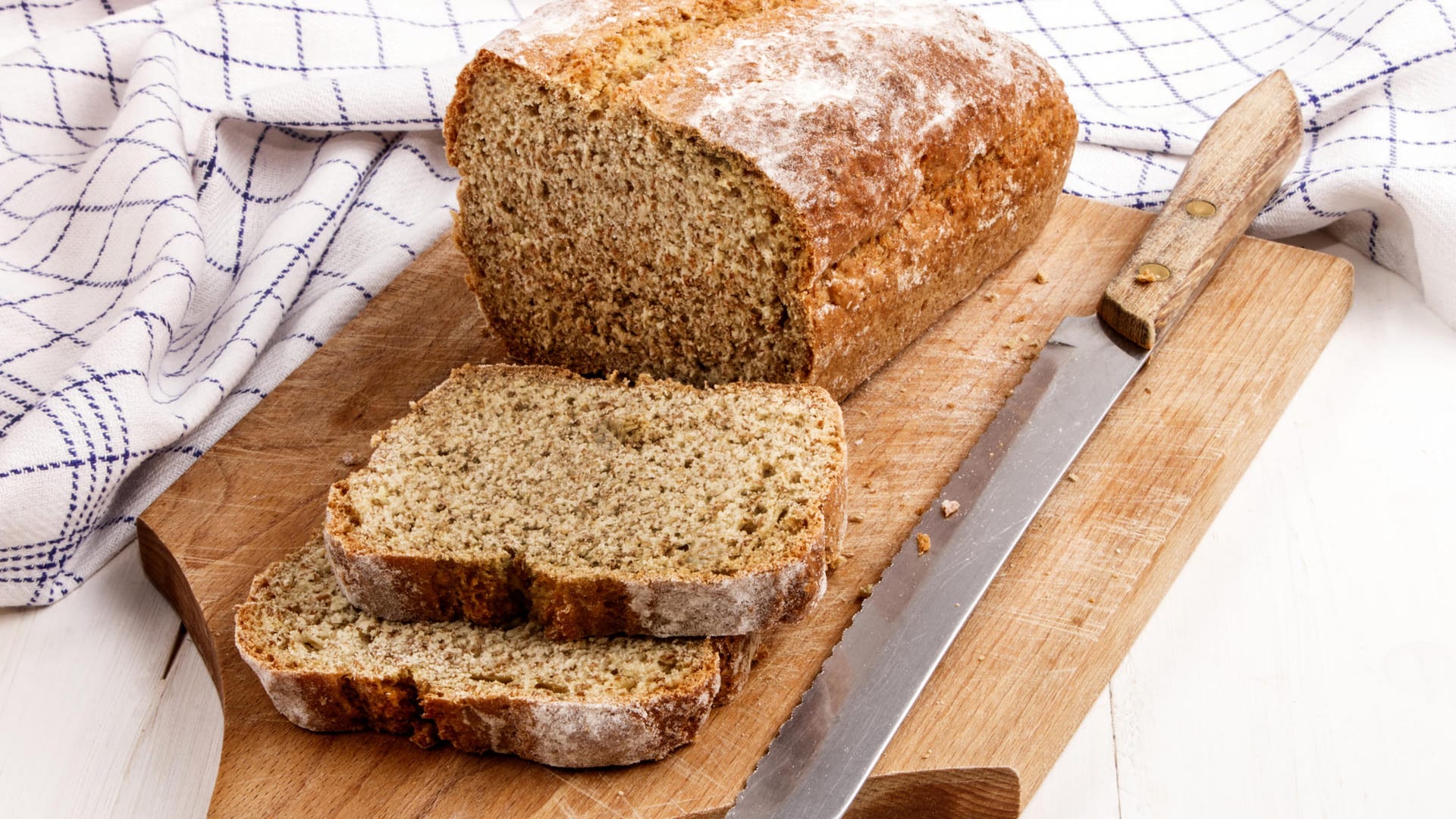 Ein aufgeschnittenes Brot auf einem Holzbrett.