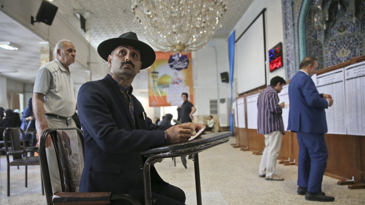 Ein Mann füllt einen Stimmzettel in einem Wahllokal in Teheran aus.