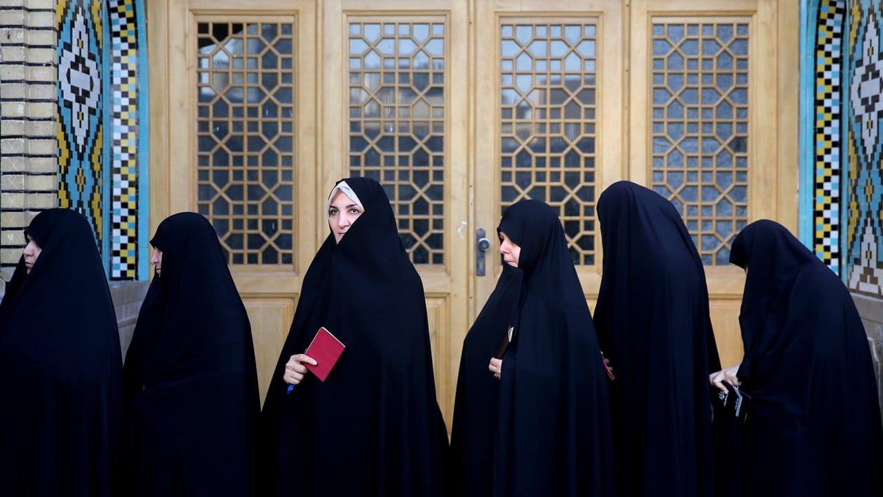 Iranische Frauen stehen vor einem Wahllokal in Ghom.