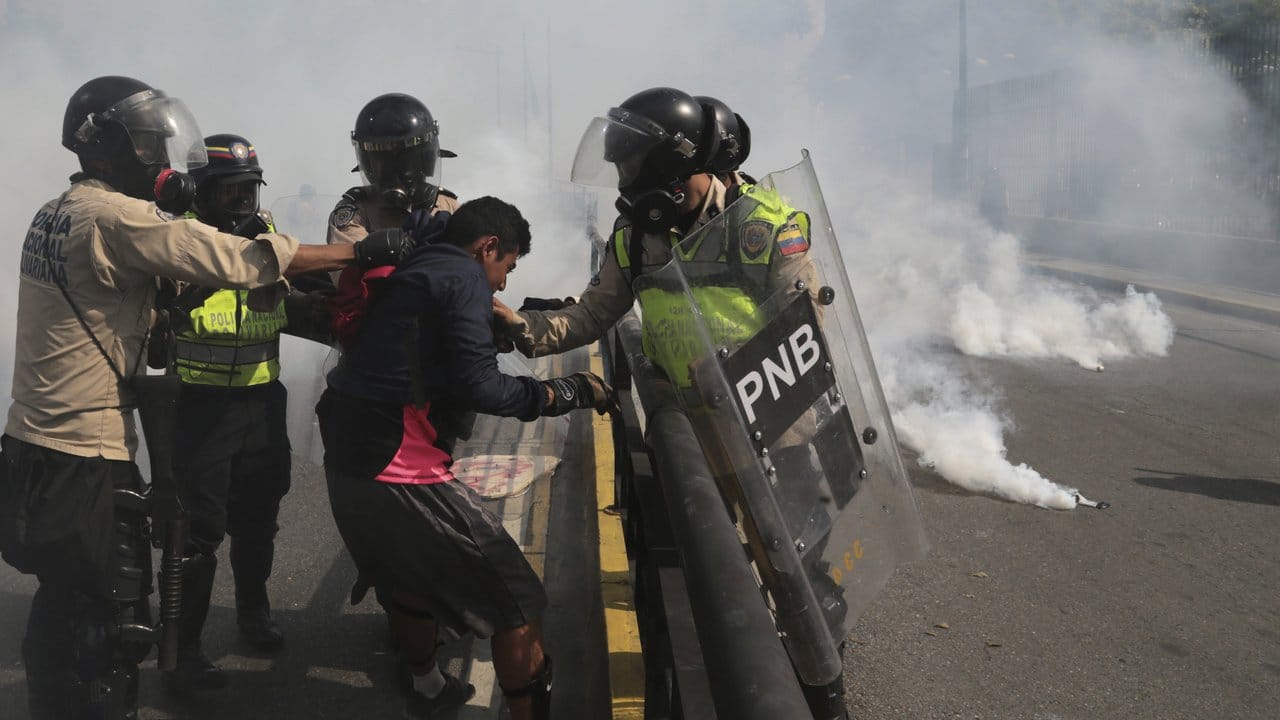 Venezolanische Sicherheitskräfte nehmen in Caracas einen Demonstranten fest. Venezolanische Sicherheitskräfte nehmen in Caracas einen Demonstranten fest.
