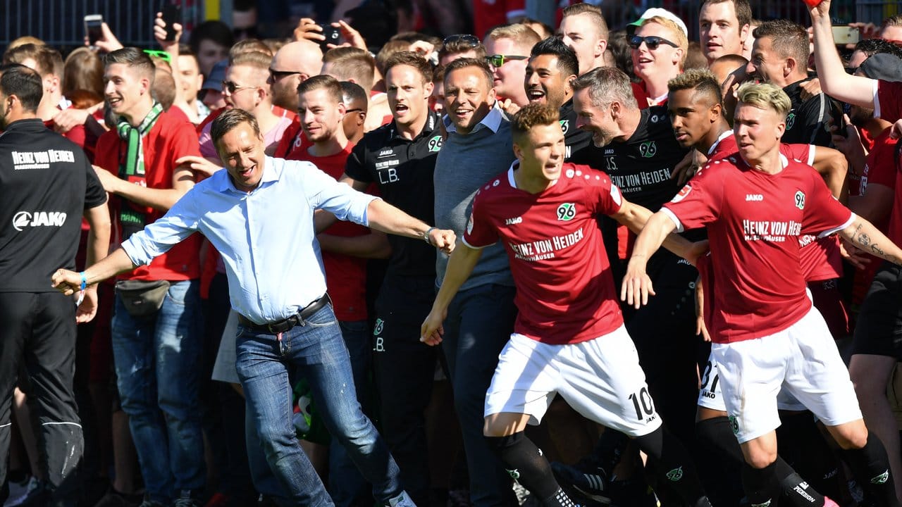 Horst Heldt (l) plant trotz der Aufstiegsfeierlichkeiten bereits das Bundesliga-Team der Hannoveraner.