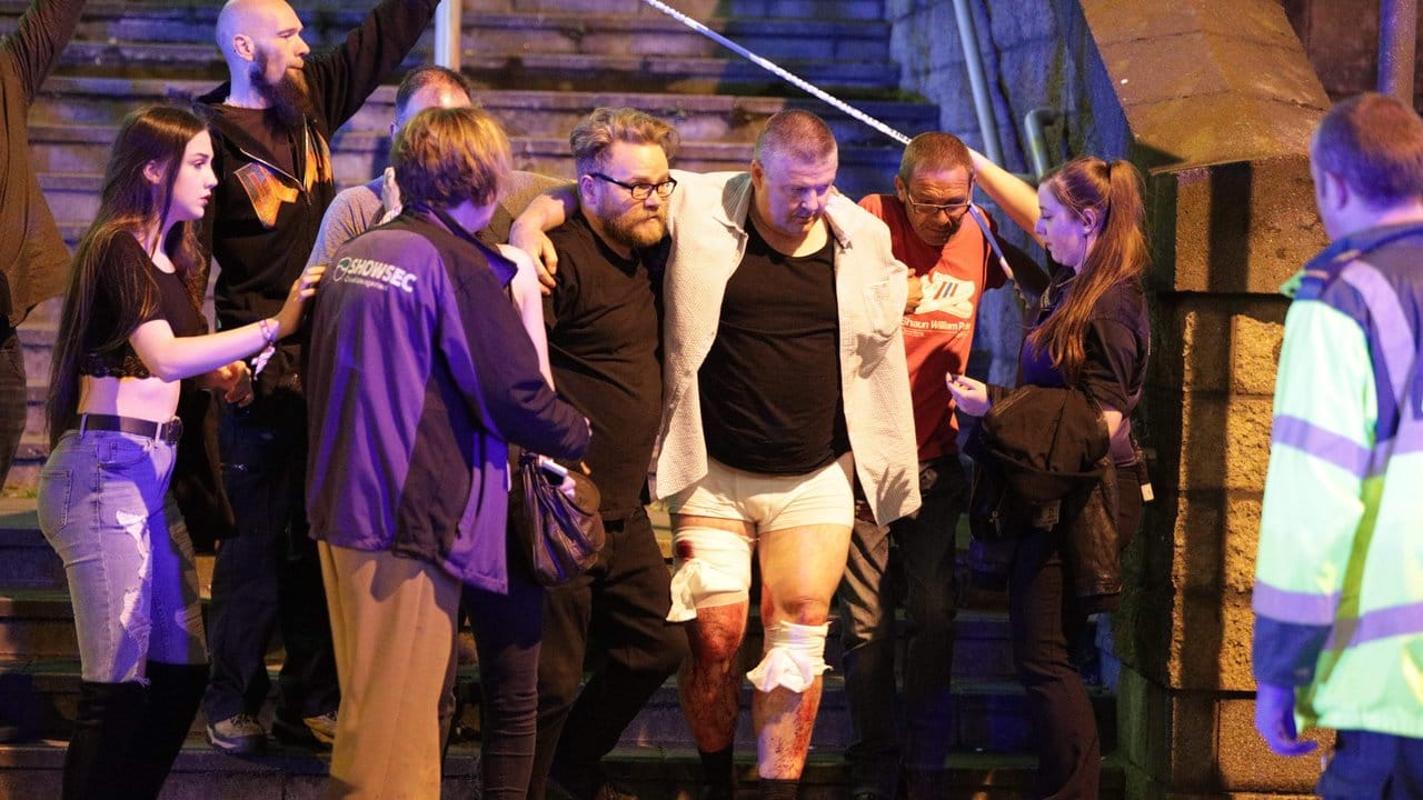 Helfer bringen einen Verletzten vom Ort der Explosion in der Nähe der Manchester Arena.