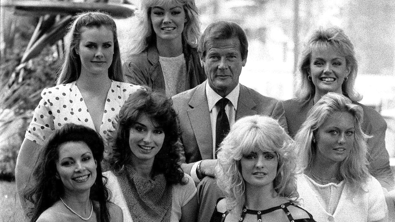 Roger Moore 1983 inmitten von sieben Darstellerinnen aus dem Film "Octopussy".