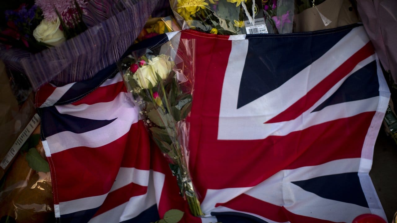 Ein Union Jack, Blumen und Kerzen liegen in Manchester nach einer Gedenkfeier auf dem Albert Square.