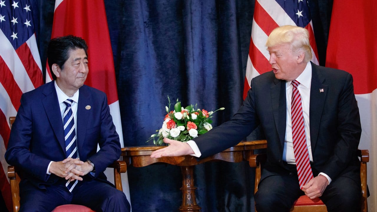 US-Präsident Donald Trump reicht dem japanischen Premier Shinzo Abe die Hand.