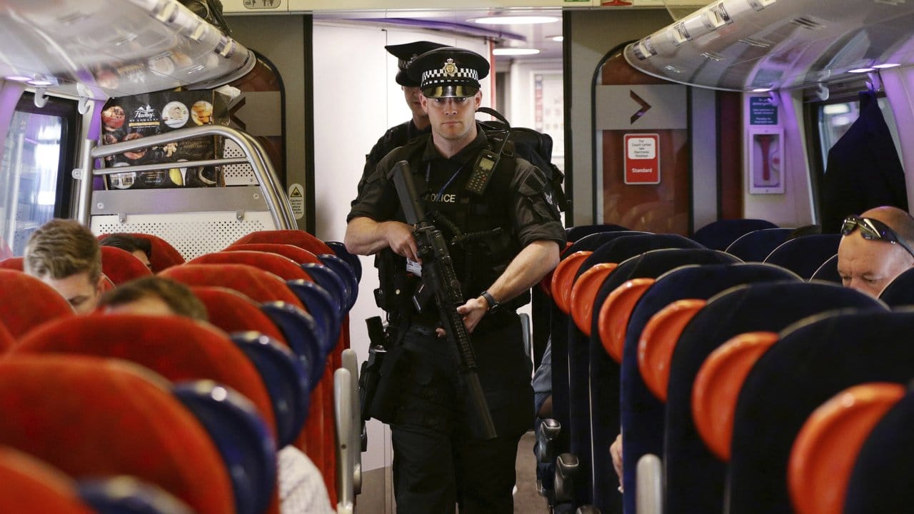 Schwer bewaffnete Polizisten patrouillieren in London an Bord eines Zuges, der nach Birmingham unterwegs ist.