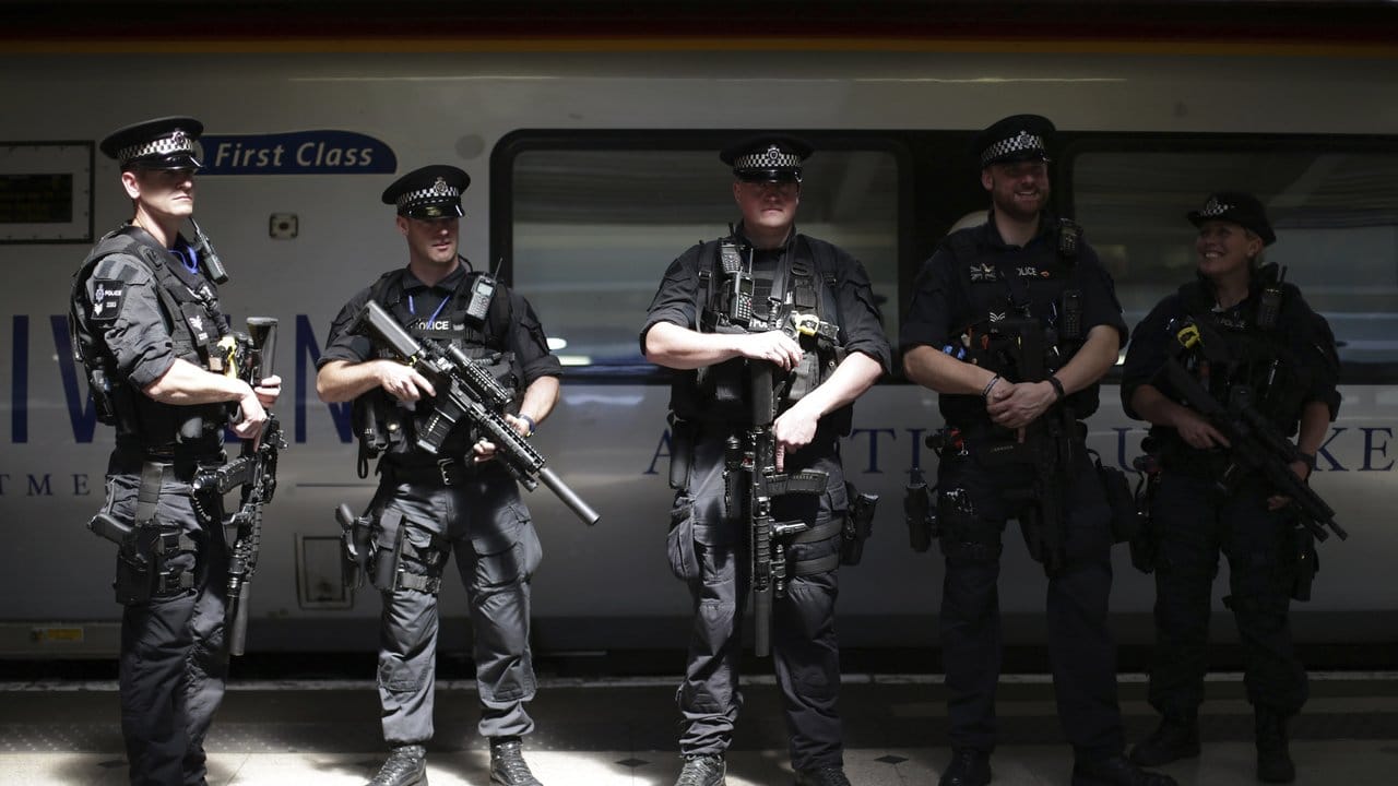 Schwer bewaffnete Polizisten patrouillieren auf dem Euston-Bahnhof in London. Schwer bewaffnete Polizisten patrouillieren auf dem Euston-Bahnhof in London.