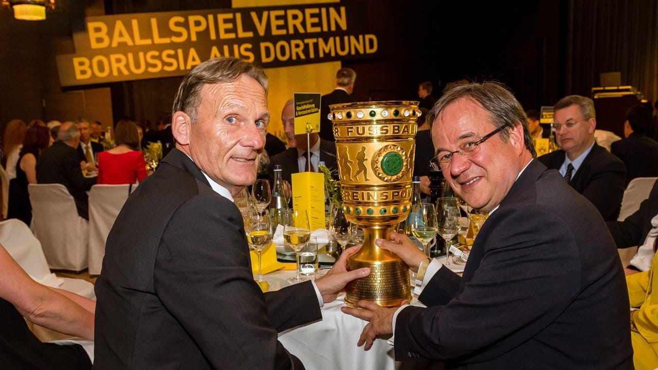 BVB-Geschäftsführer Hans-Joachim Watzke (l) und der designierte nordrhein-westfälische Ministerpräsident Armin Laschet posieren in Berlin mit dem DFB-Pokal.