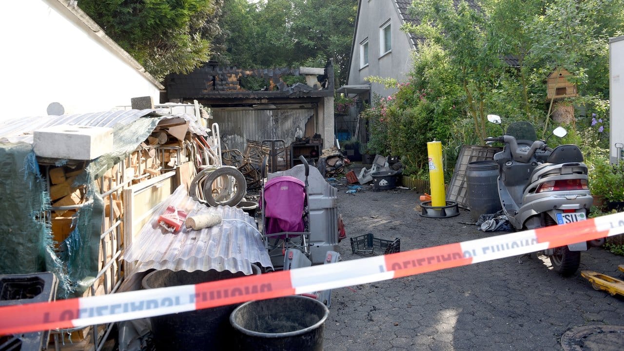 Eine Polizeiabsperrung am Zugang zu dem Grundstück des Einfamilienhauses. Eine Polizeiabsperrung am Zugang zu dem Grundstück des Einfamilienhauses.
