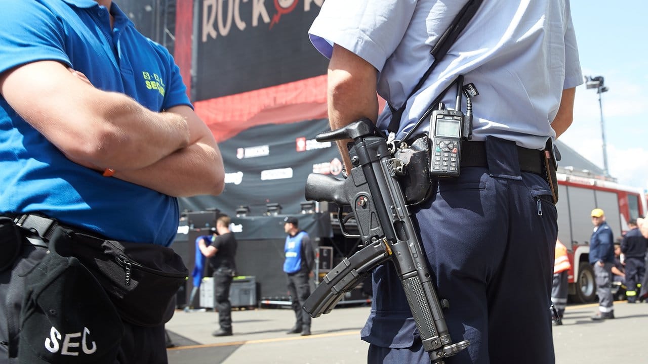Sicherheit ganz vorn: Ein Polizist mit Maschinenpistole und ein Mitarbeiter einer Sicherheitsfirma stehen neben der Hauptbühne des Musikfestivals "Rock am Ring" in Nürburg.