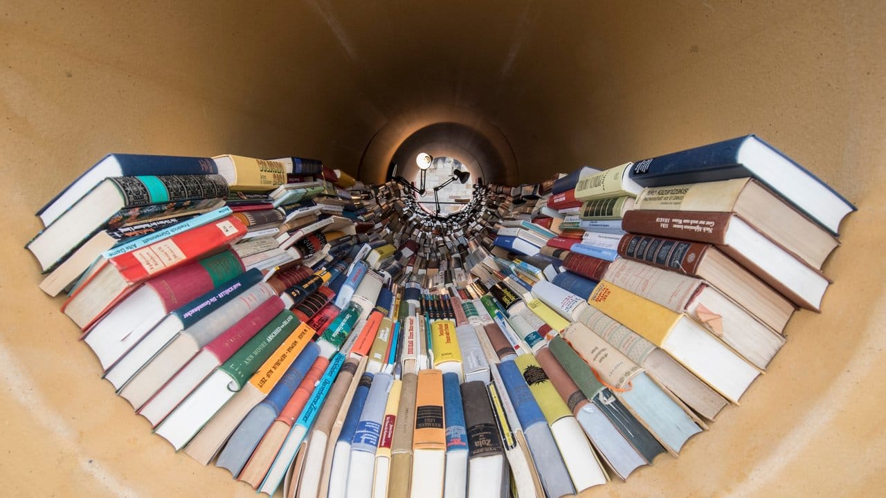 Bücher und Leselampen in dem Röhren-Kunstwerk von Hiwa K. Bücher und Leselampen in dem Röhren-Kunstwerk von Hiwa K.