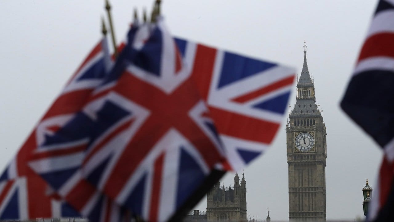 Britische Flaggen vor dem Big Ben am Palace of Westminster, in dem das britische Parlament tagt.