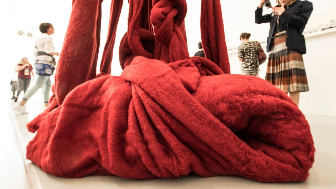 Cecilia Vicuñas Installation besteht aus riesigen Fäden ungesponnener Wolle, die purpurrot gefärbt wurde. Cecilia Vicuñas Installation besteht aus riesigen Fäden ungesponnener Wolle, die purpurrot gefärbt wurde.