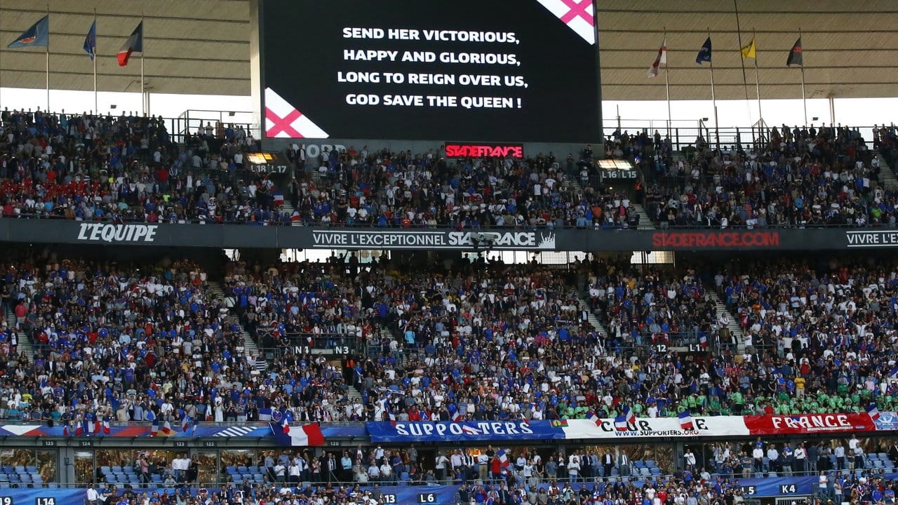 Die Worte der britischen Nationalhymne "God Save the Queen" werden im Stade de France auf einem großen Bildschirm angezeigt.