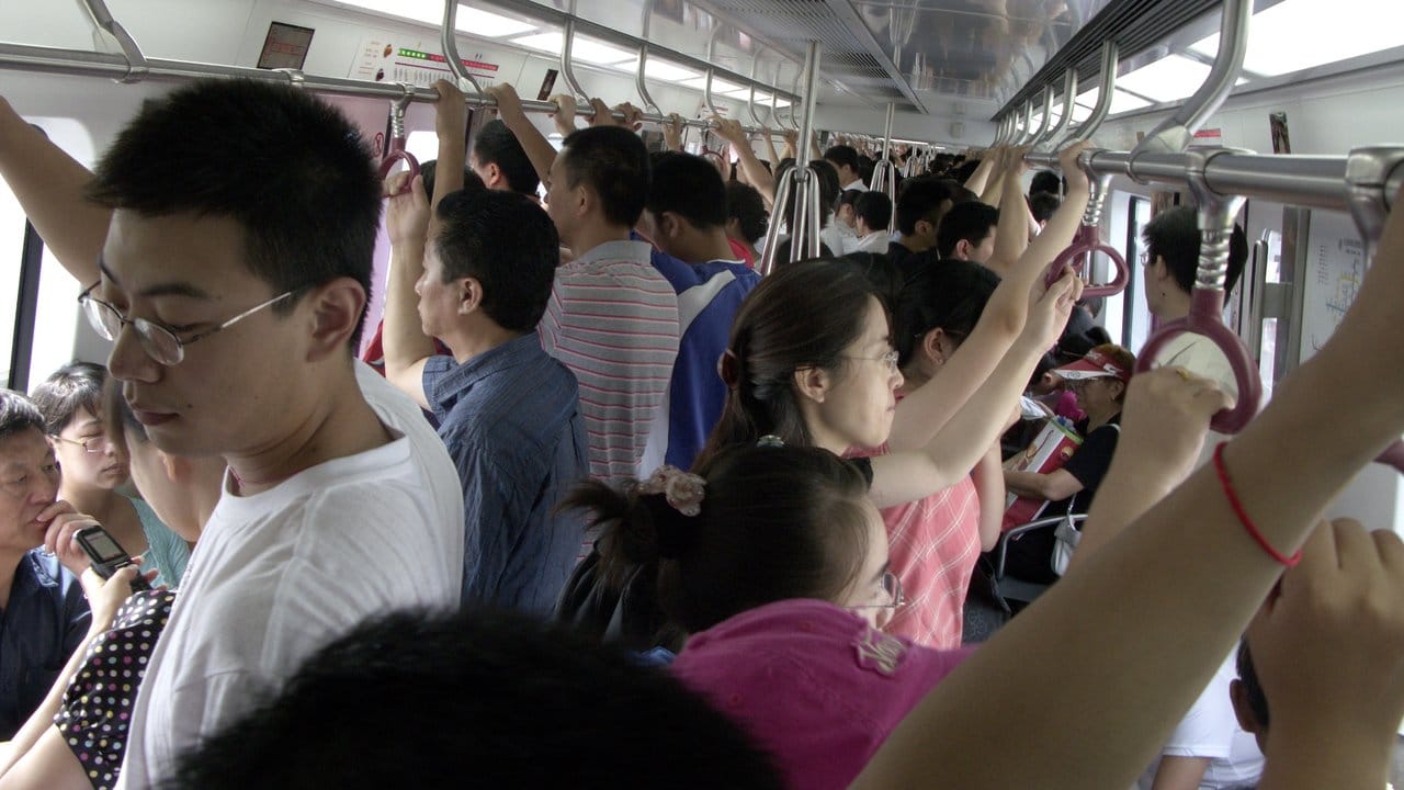 Menschen über Menschen in in einer U-Bahn in Peking während der Olympischen Spiele.
