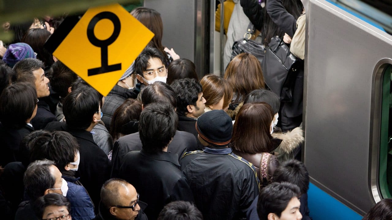 Pendler drängeln sich in Tokio in eine U-Bahn.