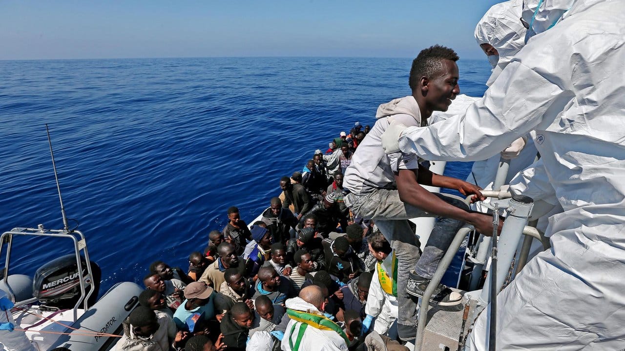 Gerettet: Auf dem Mittelmeer vor Italien besteigen Migranten ein Schiff der Guardia di Finanza. Gerettet: Auf dem Mittelmeer vor Italien besteigen Migranten ein Schiff der Guardia di Finanza.