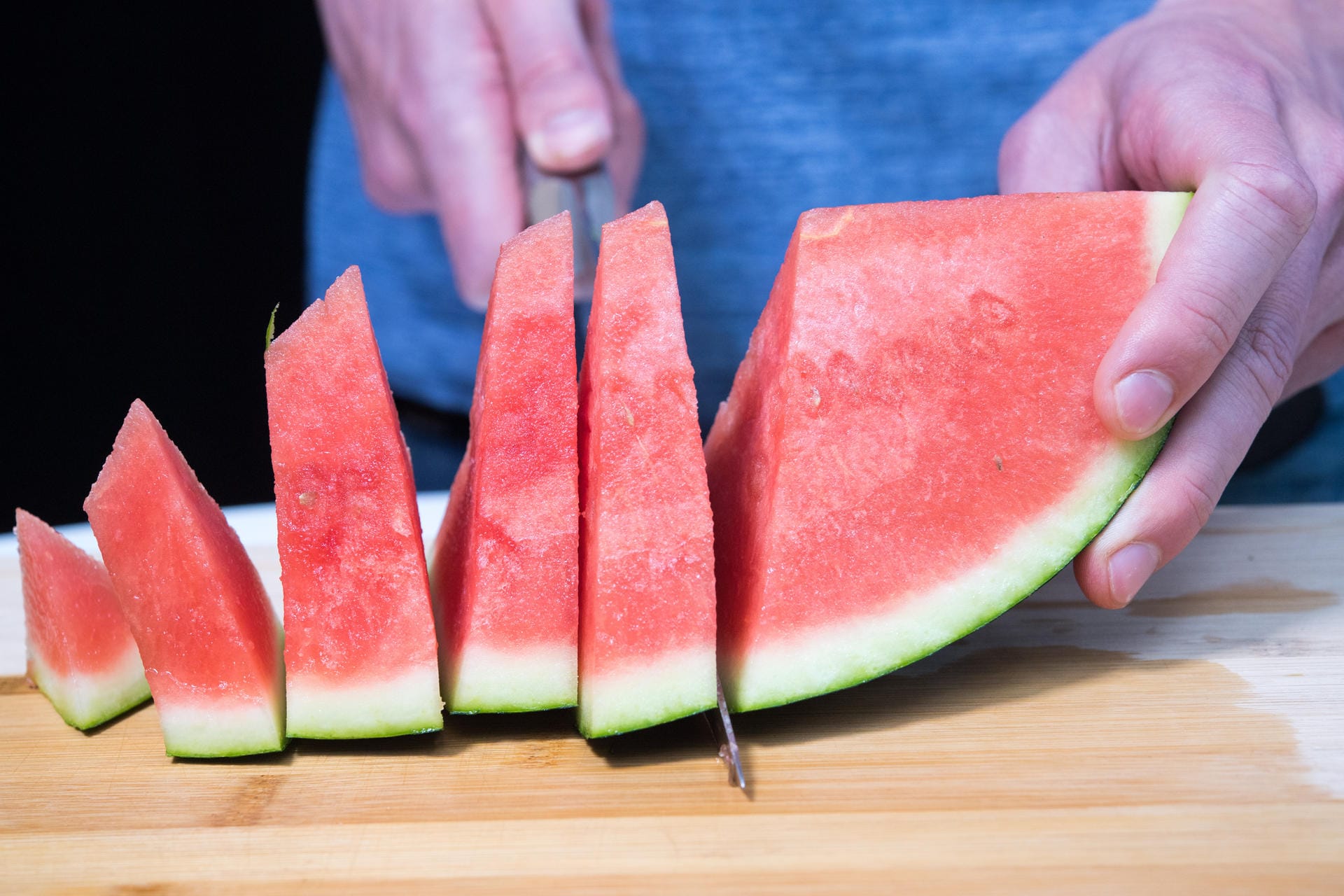 Die Melonenstücke in daumenbreite Scheiben schneiden, sodass Dreiecke entstehen.