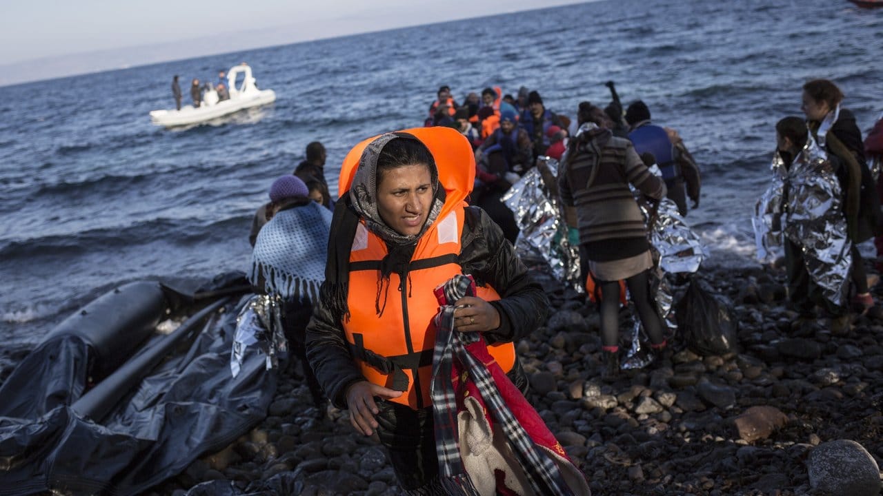 Eine Afghanin verlässt im Norden der griechischen Mittelmeerinsel Lesbos ein kaum seetüchtiges Schlauchboot.