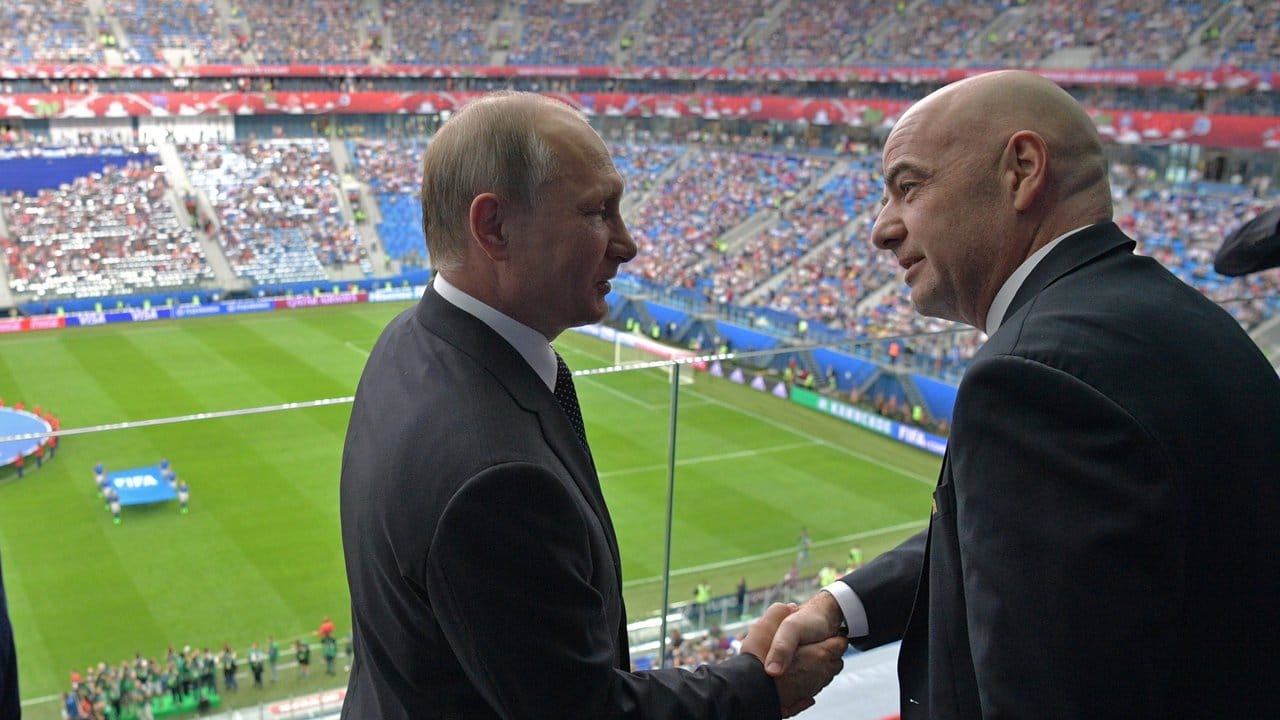 Russlands Präsident Wladimir Putin (l) und FIFA-Präsident Gianni Infantino geben sich vor dem Spiel des Gastgeber gegen Neuseeland die Hand.
