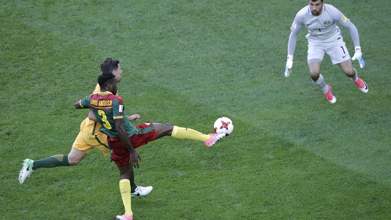 Der Kameruner Andre-Frank Zambo Anguissa (vorn) erzielt mit einem Lupfer gegen Australiens Torwart Mathew Ryan (r) das Tor zum 1:0.