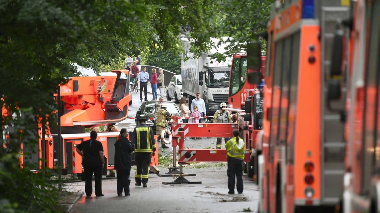 Feuerwehrmänner sind an der gesperrten Zufahrt zur Insel Schwanenwerder in Berlin mit der Sicherung eines beschädigten Baumes beschäftigt. Feuerwehrmänner sind an der gesperrten Zufahrt zur Insel Schwanenwerder in Berlin mit der Sicherung eines beschädigten Baumes beschäftigt.