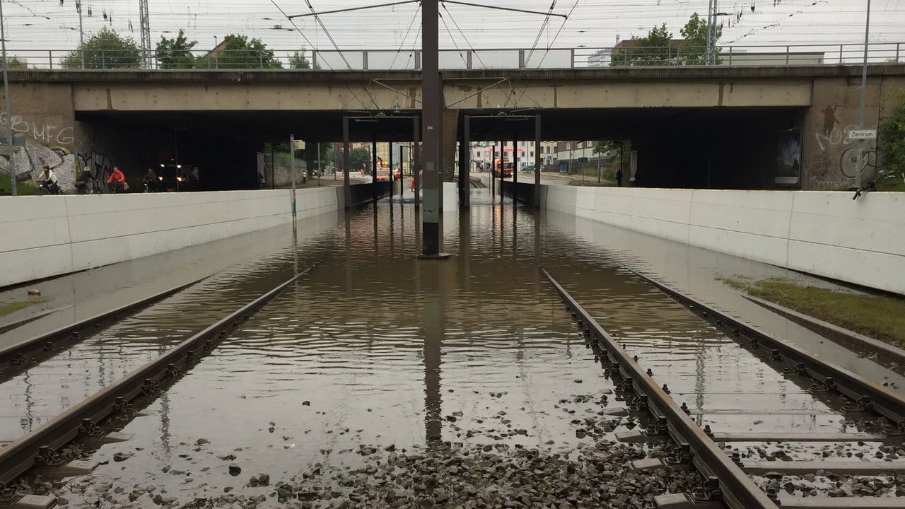 Unter der Bahnbrücke am Südring in Rostock stehen nach den Unwettern in der Nacht die Straßenbahnschienen unter Wasser. Unter der Bahnbrücke am Südring in Rostock stehen nach den Unwettern in der Nacht die Straßenbahnschienen unter Wasser.