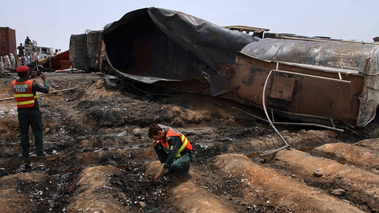 Rettungskräfte untersuchen die Umgebung des explodierten Tanklastwagens.