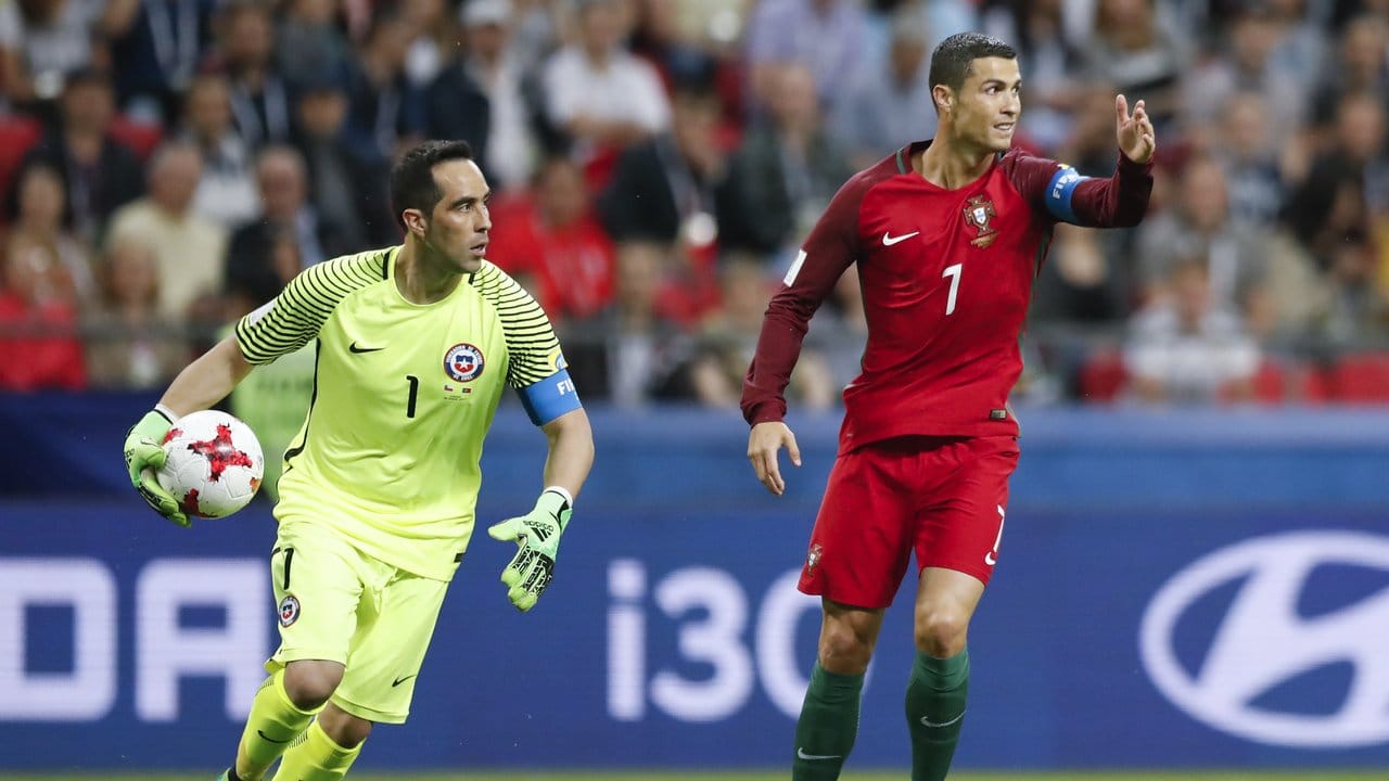 Cristiano Ronaldo (r) gestikuliert neben Chiles Torhüter Claudio Bravo, der ein Tor verhindert hat.