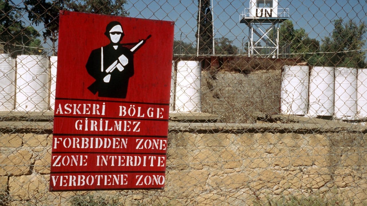 Ein Plakat auf der türkischen Seite der innerzyprischen Grenze weist auf die von der UN bewachte Verbotene Zone hin, die den türkischen und griechischen Teil voneinander trennt. Ein Plakat auf der türkischen Seite der innerzyprischen Grenze weist auf die von der UN bewachte Verbotene Zone hin, die den türkischen und griechischen Teil voneinander trennt.