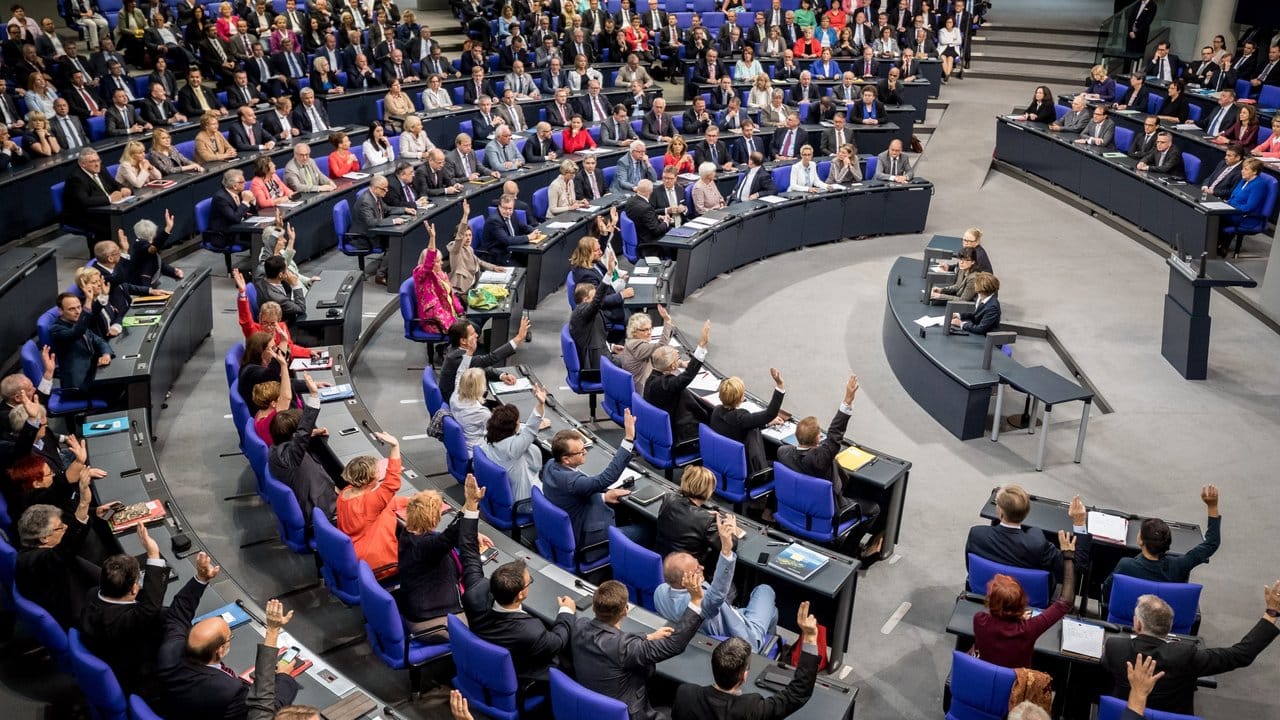 Im Bundestag halten Abgeordnete der Grünen und SPD (Vordergrund) bei der Abstimmung zur Änderung der Tagesordnung die Hände hoch. Im Bundestag halten Abgeordnete der Grünen und SPD (Vordergrund) bei der Abstimmung zur Änderung der Tagesordnung die Hände hoch.