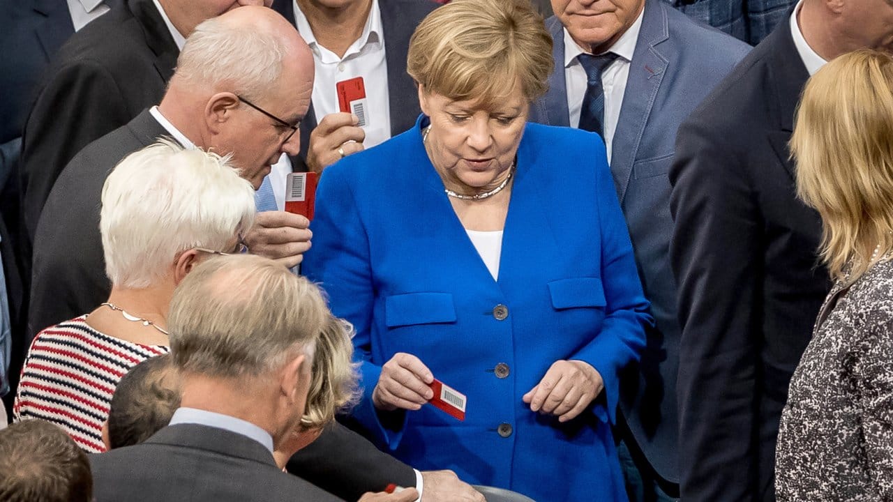 Bundeskanzlerin Angela Merkel wirft ihre rote Stimmkarte mit "NEIN" ein.