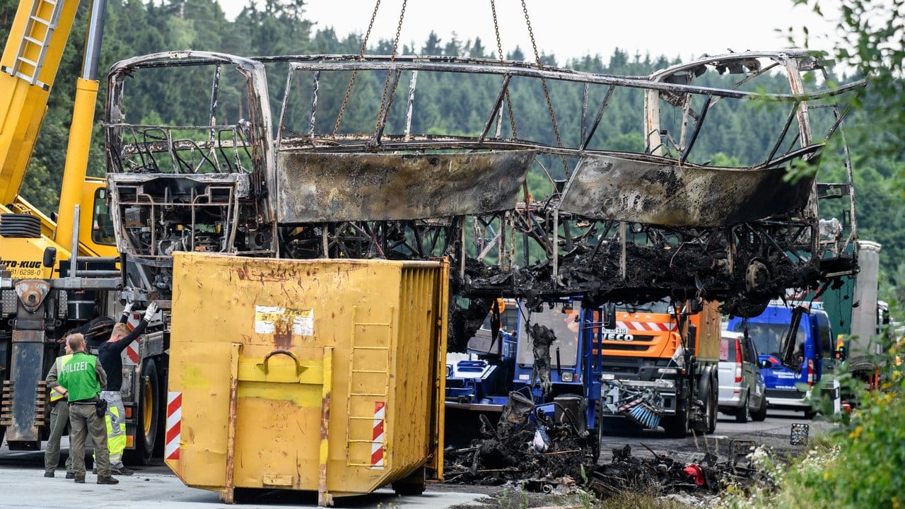 Das Wrack des völlig ausgebrannten Reisebusses wird von einem Kran geborgen. Das Wrack des völlig ausgebrannten Reisebusses wird von einem Kran geborgen.