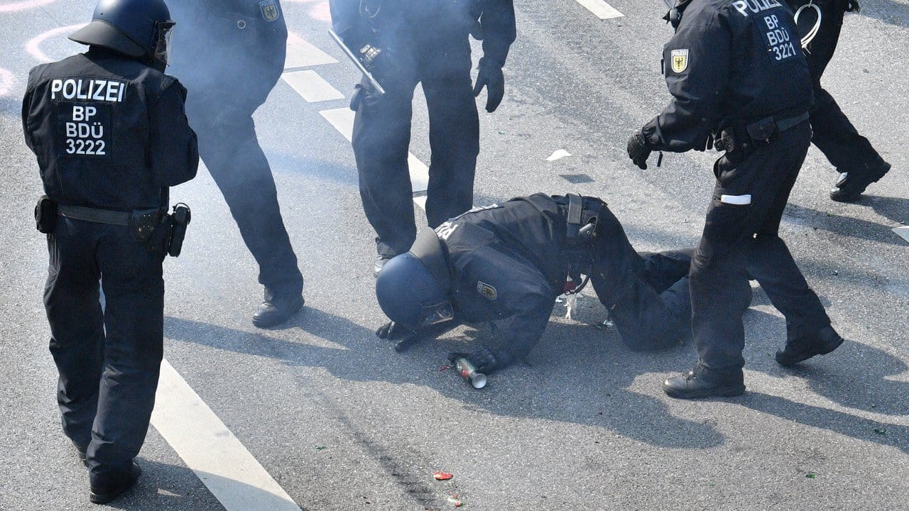 Verletzte auf beiden Seiten: Polizisten kümmern sich um einen am Boden liegenden Kollegen. Verletzte auf beiden Seiten: Polizisten kümmern sich um einen am Boden liegenden Kollegen.