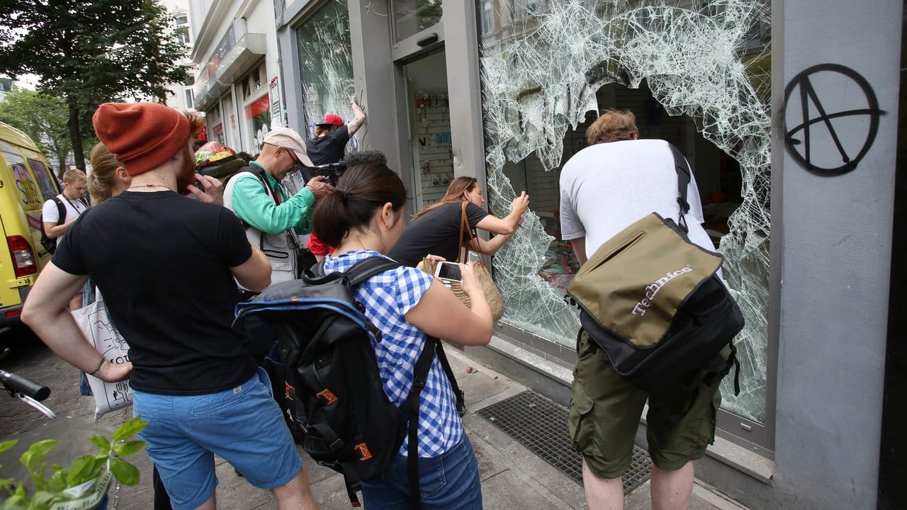 Gaffer: Schaulustige fotografieren den geplünderten Drogeriemarkt im Hamburger Schanzenviertel. Gaffer: Schaulustige fotografieren den geplünderten Drogeriemarkt im Hamburger Schanzenviertel.