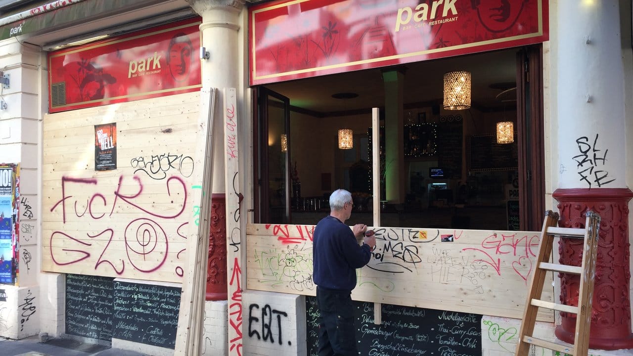 Hoffen auf Ruhe: Ein Mann entfernt an einem Cafe im Schanzenviertel in Hamburg die schützenden Holzplatten. Hoffen auf Ruhe: Ein Mann entfernt an einem Cafe im Schanzenviertel in Hamburg die schützenden Holzplatten.
