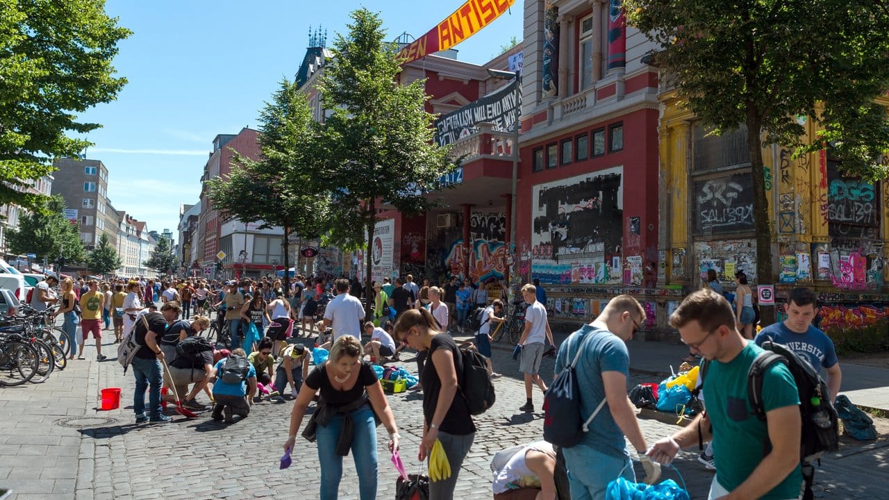 Bewohner räumen in Hamburg vor der Roten Flora die Straße auf. Bewohner räumen in Hamburg vor der Roten Flora die Straße auf.