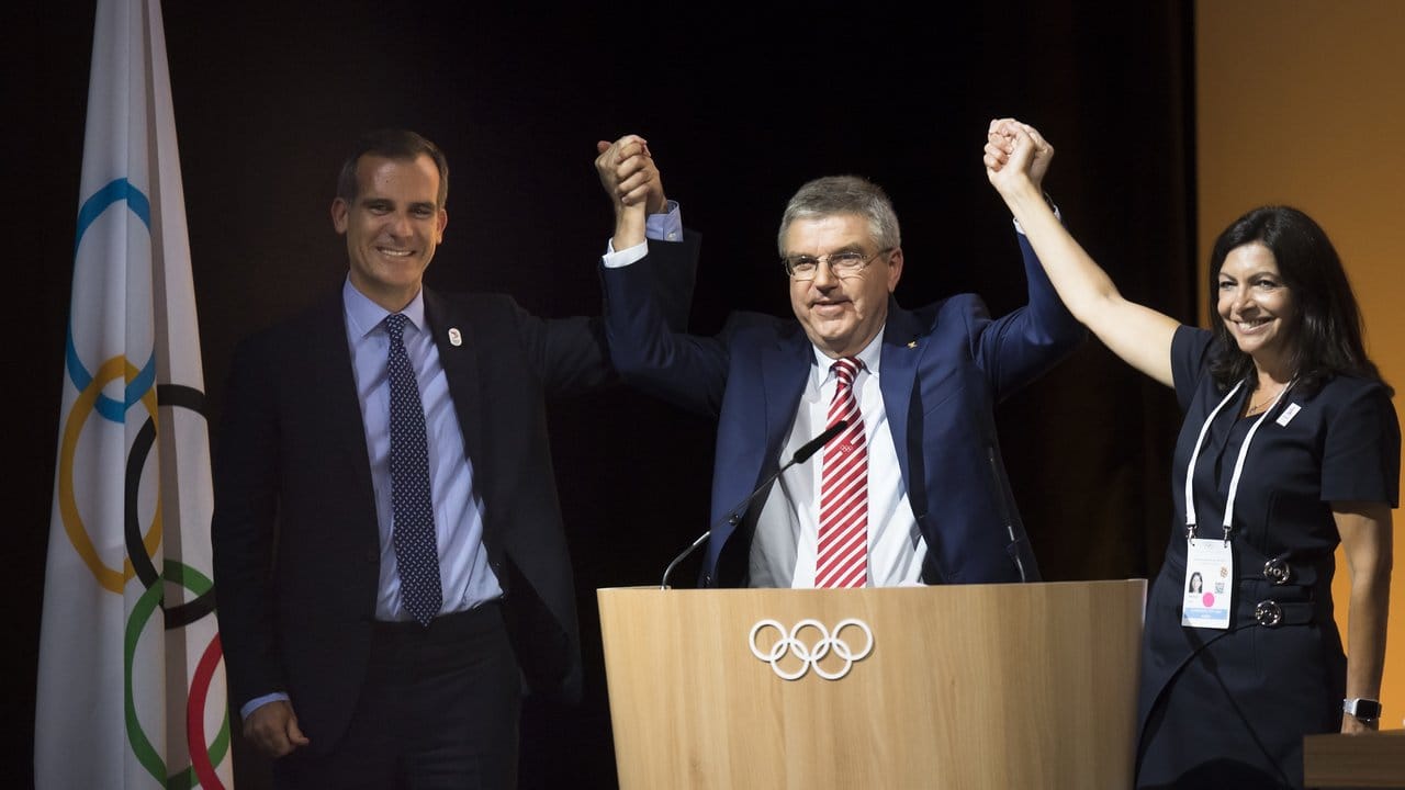 Demonstrativ hat IOC-Präsident Thomas Bach (M) die Hände der Pariser Bürgermeisterin Anne Hidalgo (r) und von dem Bürgermeister von Los Angeles Eric Garcetti ergriffen.