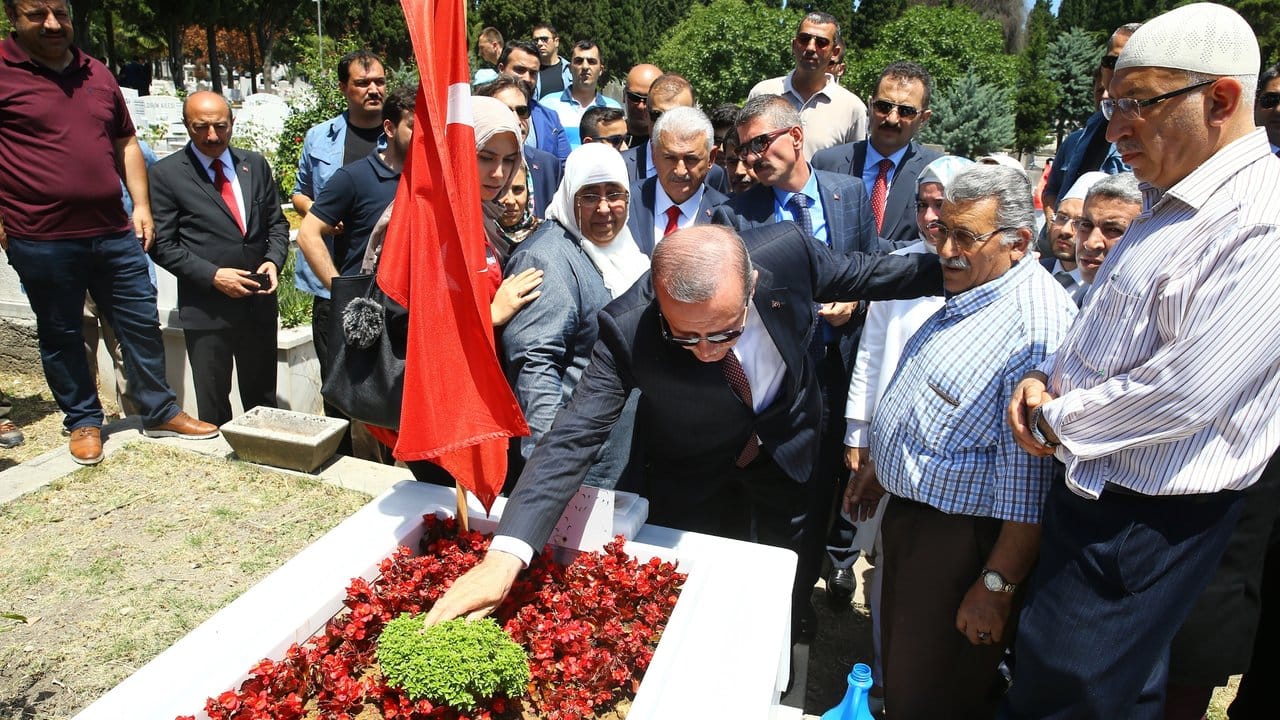Der türkische Präsident Recep Tayyip Erdogan legt in Istanbul Blumen auf das Grab eines Opfers des Putschversuches vor einem Jahr.