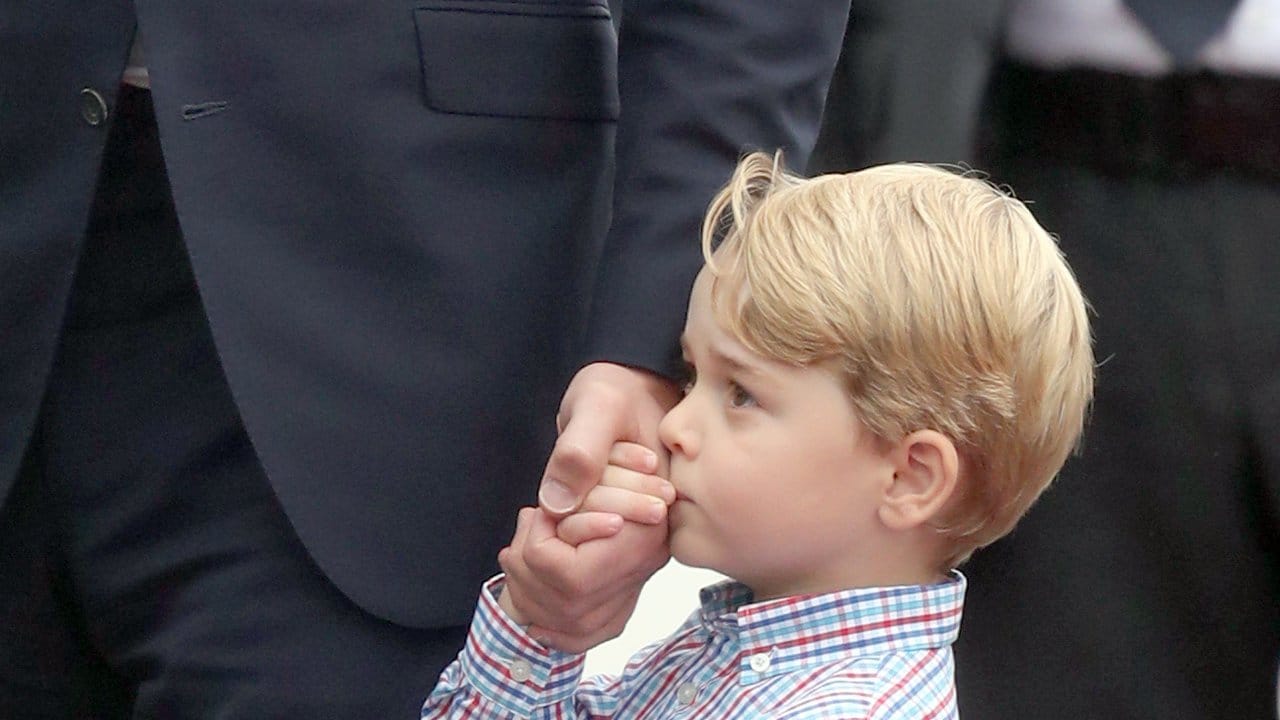Der Kleine Prinz hält sich an Papa fest.