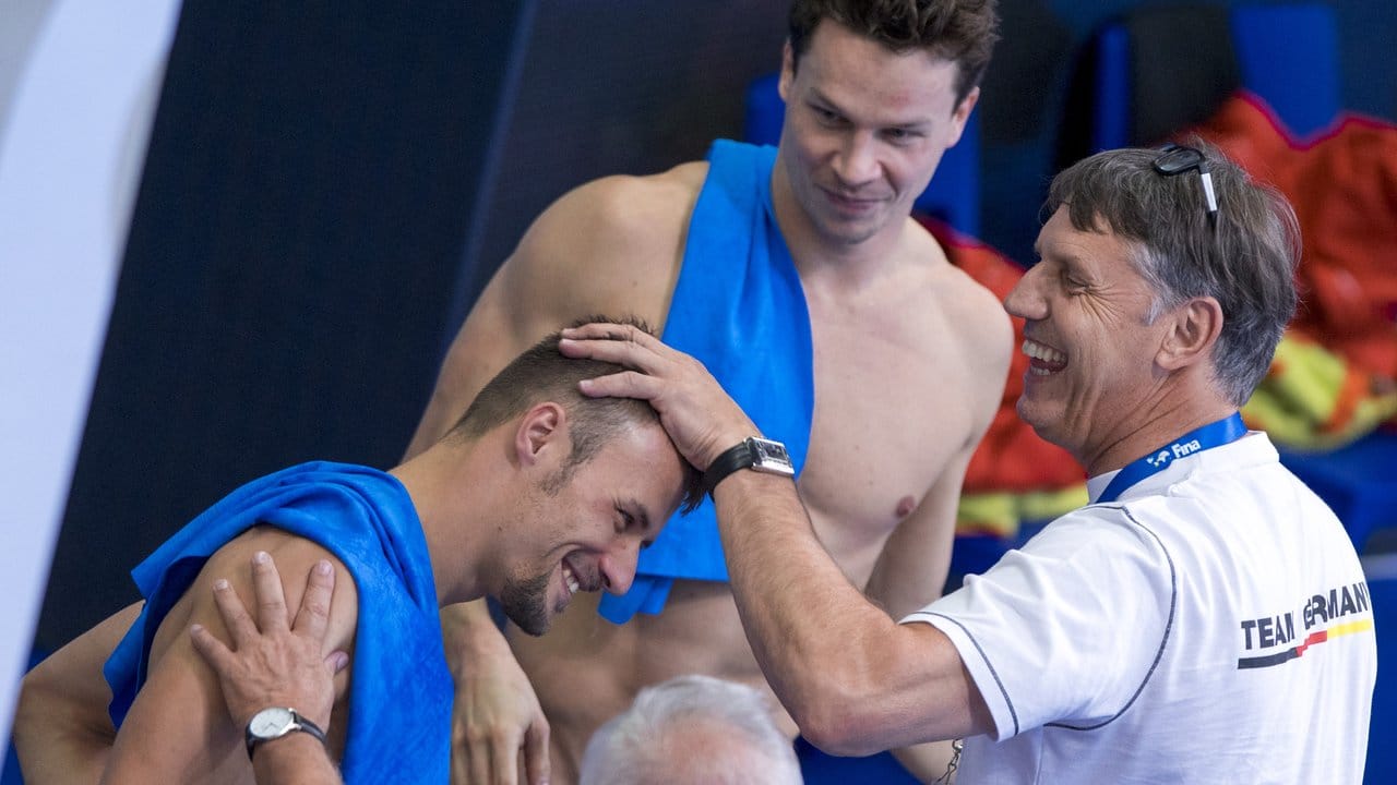 Patrick Hausding (hinten) und Sascha Klein werden vom Bundestrainer Wasserspringen Lutz Buschkow (r) beglückwünscht.