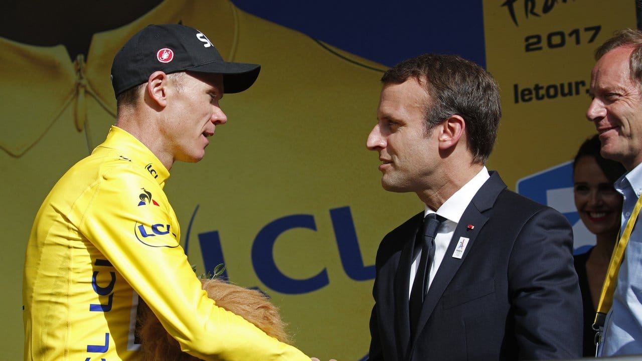 Der französische Präsident Emmanuel Macron (r) beglückwünscht Chris Froome (l) als Führenden in der Gesamtwertung.