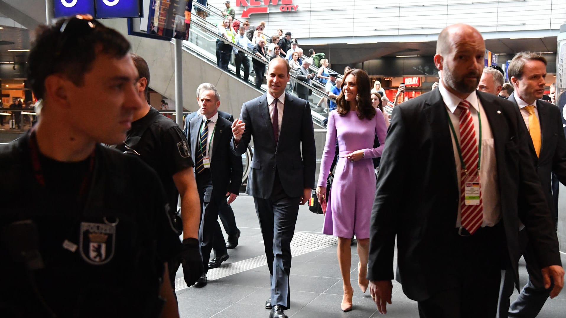 Umringt von einer Menge Sicherheitsmänner flanierten die Royals durch Mengen von Bahnreisenden.