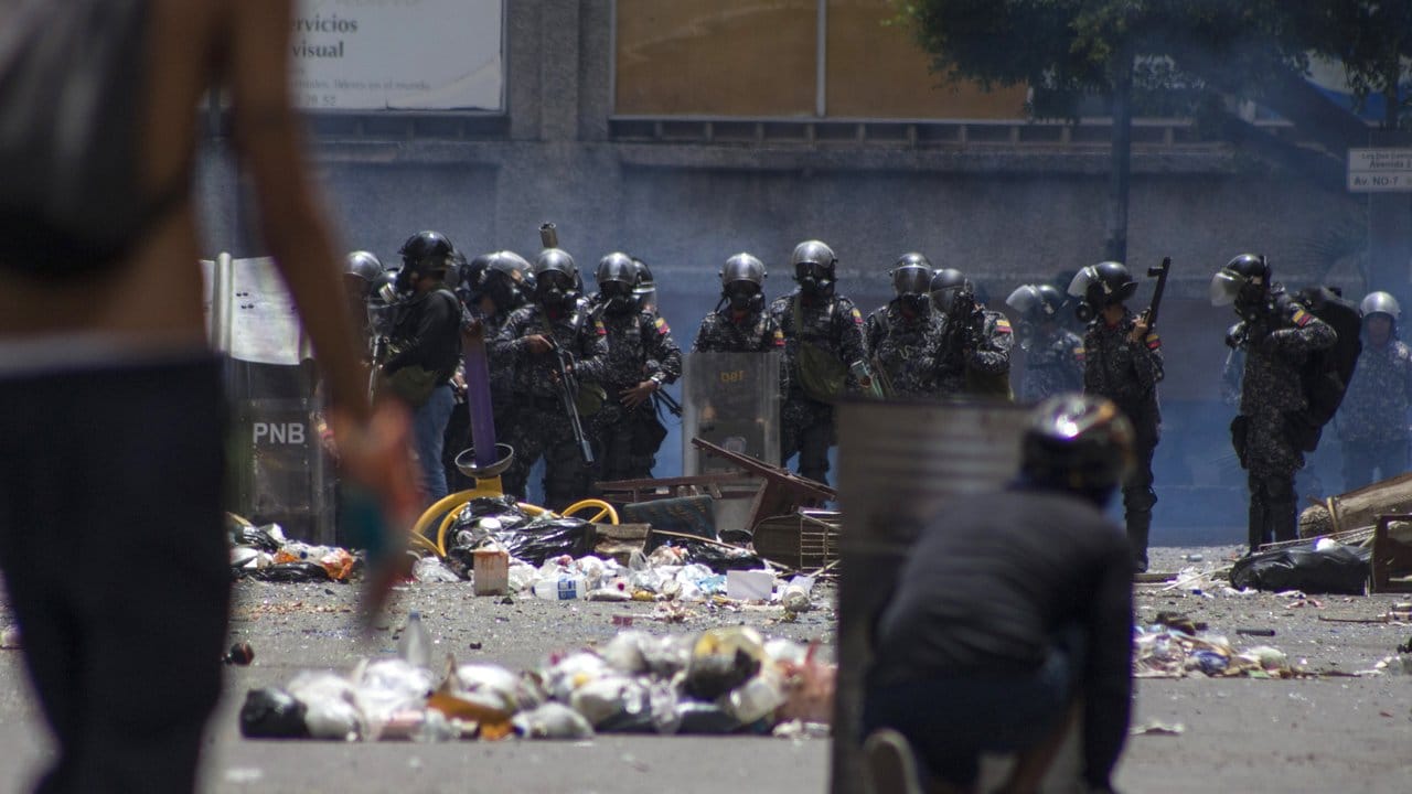 Sicherheitskräfte und Demonstranten bekämpfen sich auf einer Demonstration in Caracas.