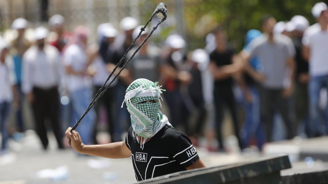 Mit einer Steinschleuder attackiert ein palästinensischer Demonstrant in Bethlehem israelische Soldaten.