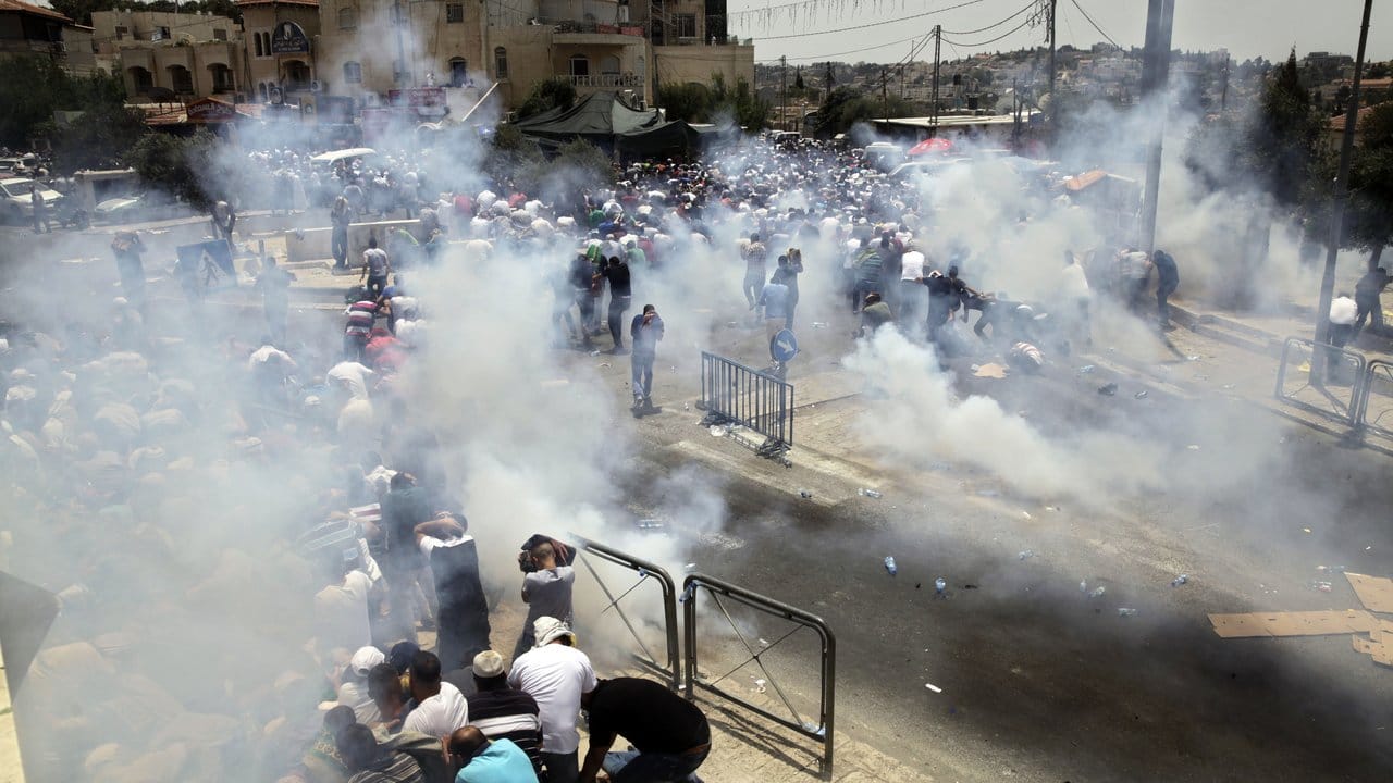 Israelische Soldaten schießen in Jerusalem mit Tränengas in Richtung palästinensischer Demonstranten.