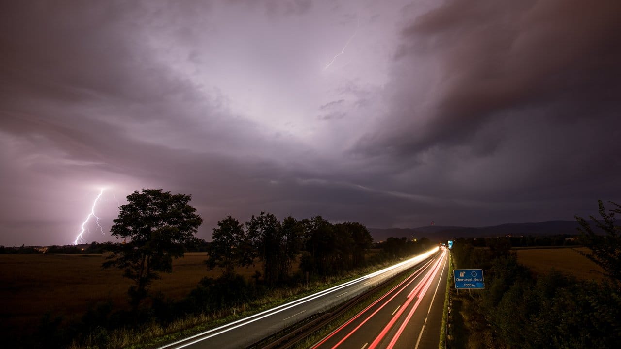 Blitze sind bei Oberursel im Taunus neben der Autobahn 661 während des Durchzugs einer Gewitterfront zu sehen.